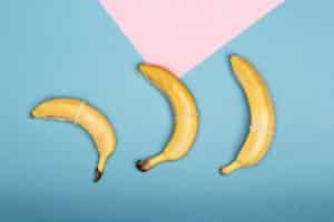 An image of three bananas on a table illustrates the different sizes when considering permanent penis enlargement.