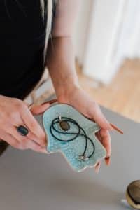 A woman displaying an amulet on a plate during Voodoo penis enlargement ritual.