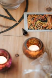 Burning candles near tarot cards during a Voodoo penis enlargement ritual.