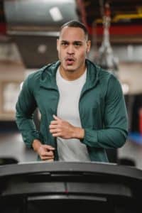 An image of a man exercising on a treadmill illustrates one of the ways to get better in bed.